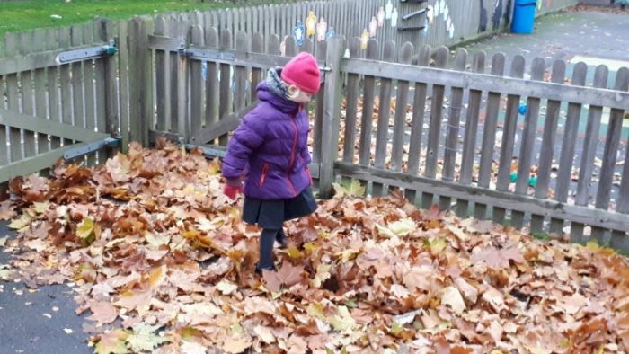 playing the leaves girl kicking them